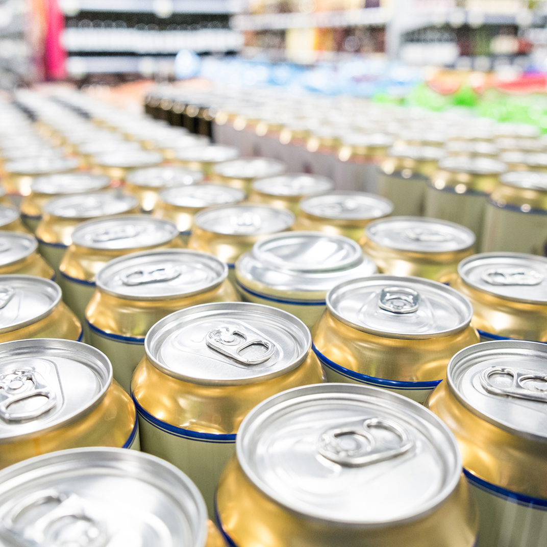 listing3 Rows of aluminum cans in store display.