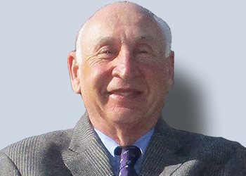 Smiling elderly man in a suit.